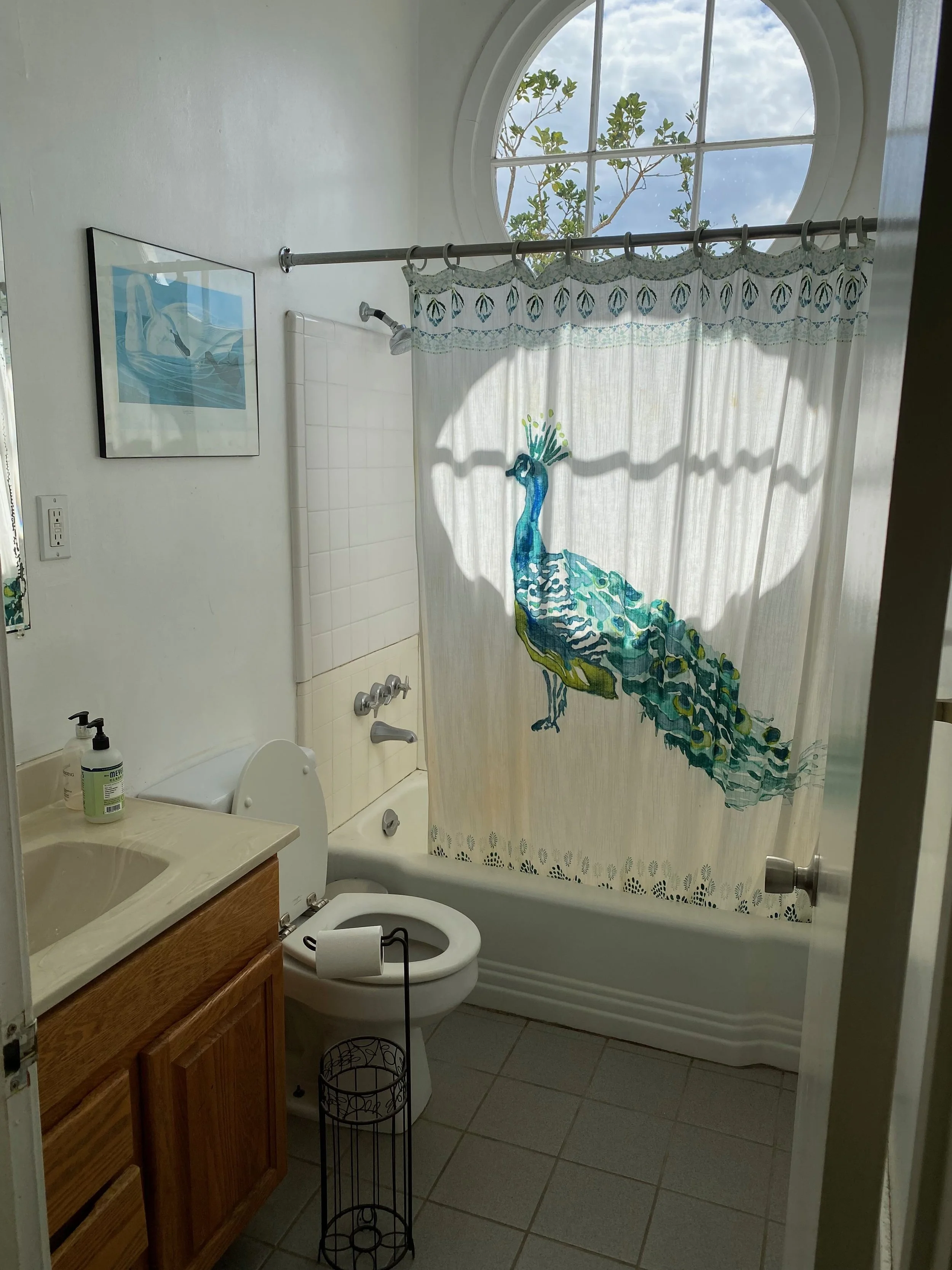 Bathroom before remodel — dated vanity, white tile floor, old fixtures